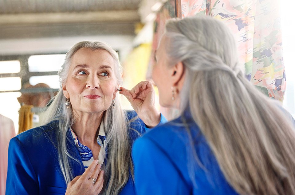 oticon_own_designer_looking_in_mirror_placing_iic